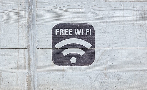 Auf einer Holzwand in einer Stuttgarter Unterkunft ist ein schwarzes WLAN-Symbol