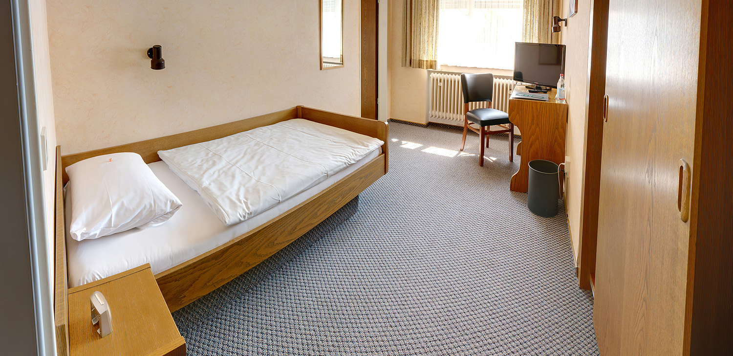 Einzelzimmer mit Schreibtisch, Fernseher und Badewanne zum Langzeitwohnen in Stuttgart