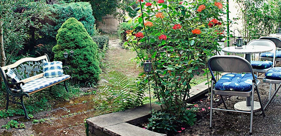 Gartenanlage mit einer Bank, Stühlen und Tischen 